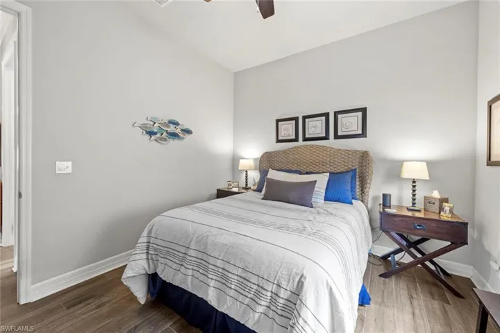 Bedroom featuring ceiling fan, baseboards, and wood finished floors