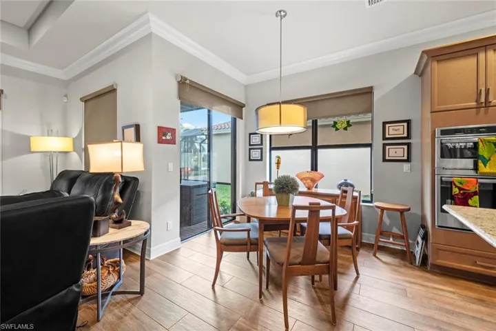 Dining space with ornamental molding, baseboards, and light wood finished floors