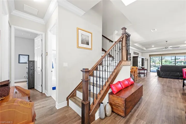 Staircase featuring crown molding, wood finished floors, and baseboards