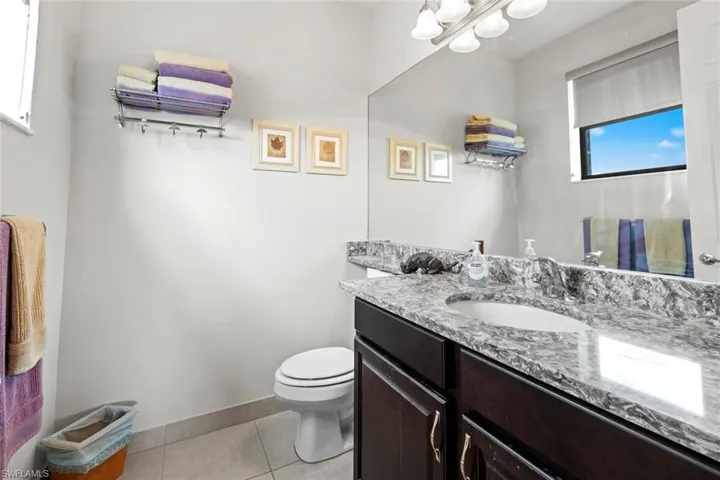 Upstairs Bathroom with vanity, tile patterned flooring, toilet, and baseboards