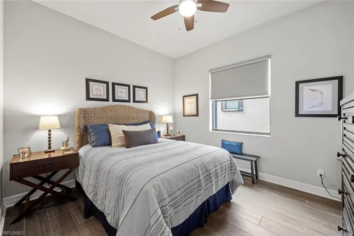 Bedroom featuring wood finished floors, a ceiling fan, and baseboards
