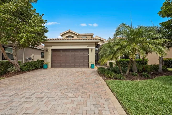 Mediterranean / spanish-style home featuring a garage, decorative driveway, a tile roof, and stucco siding