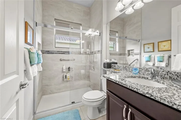 Remodeled Full bath with toilet, tile patterned floors, a shower stall, and vanity