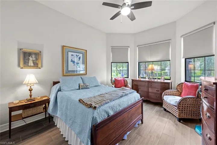Bedroom with multiple windows, wood finished floors, and a ceiling fan