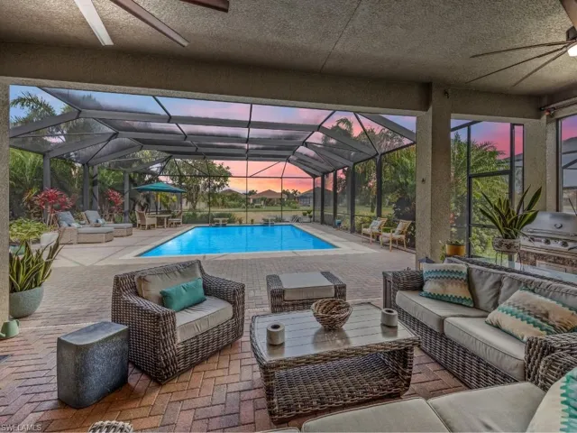 Pool with ceiling fan, lanai enclosure, outdoor lounge area, and a patio area