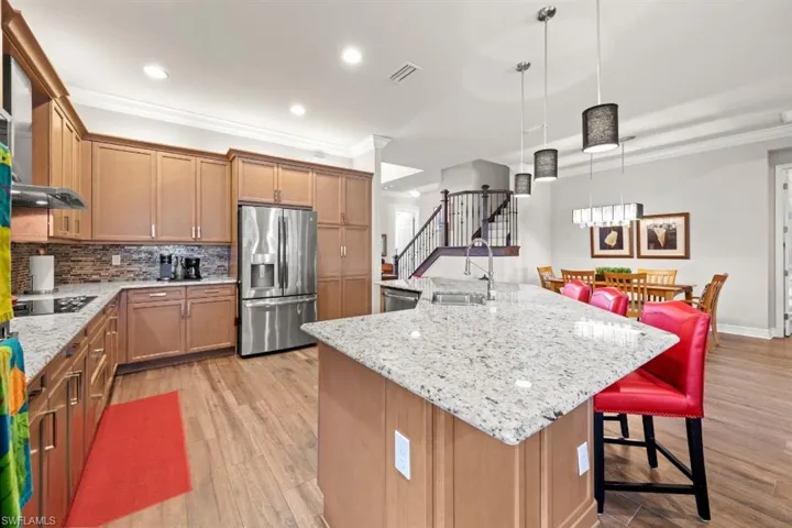 Kitchen with stainless steel appliances, a sink, decorative backsplash, and crown molding