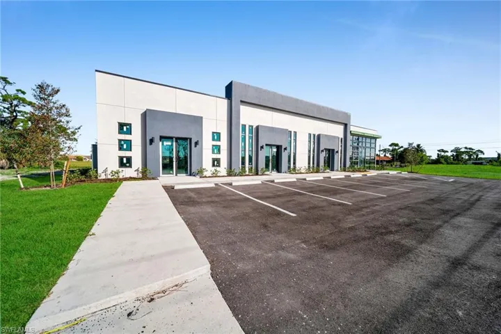 View of commercial property featuring uncovered parking