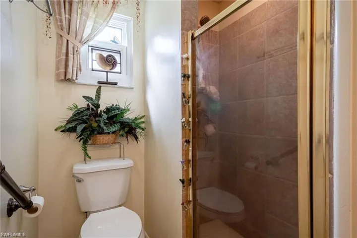 Full bathroom featuring a stall shower and toilet