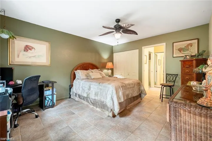 Bedroom with a closet, a ceiling fan, and an office area