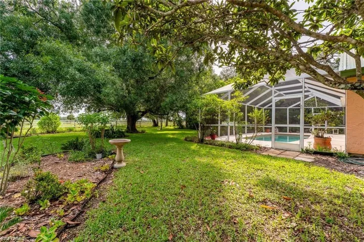 View of yard featuring a sunroom, glass enclosure, a patio area, and an outdoor pool