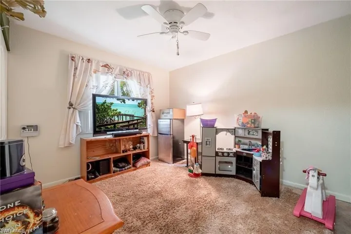 Carpeted living room with baseboards and a ceiling fan