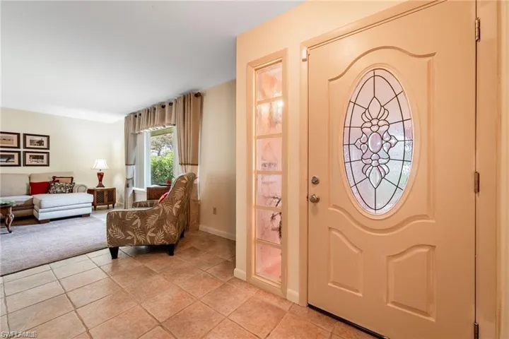 Entrance foyer with light tile patterned floors and baseboards