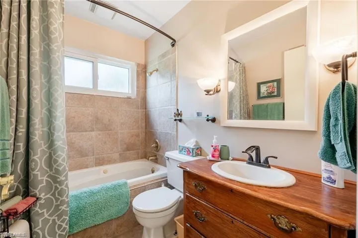 Full bath featuring tiled shower / bath and vanity