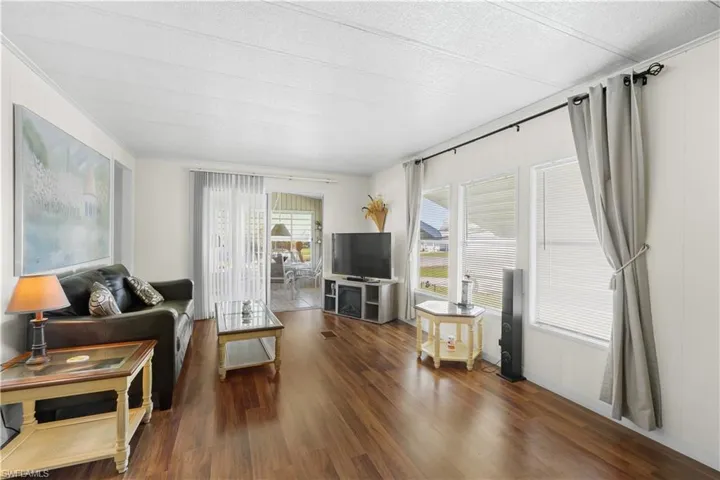 Living room featuring a textured ceiling and dark hardwood / wood-style flooring