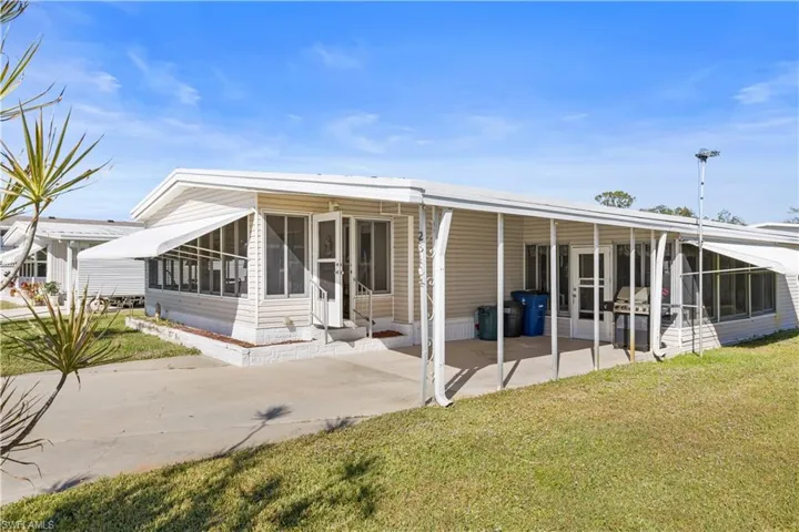 Back of property with a lawn and a patio