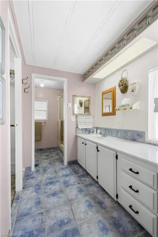 Bathroom featuring tile patterned floors, vanity, a textured ceiling, and walk in shower