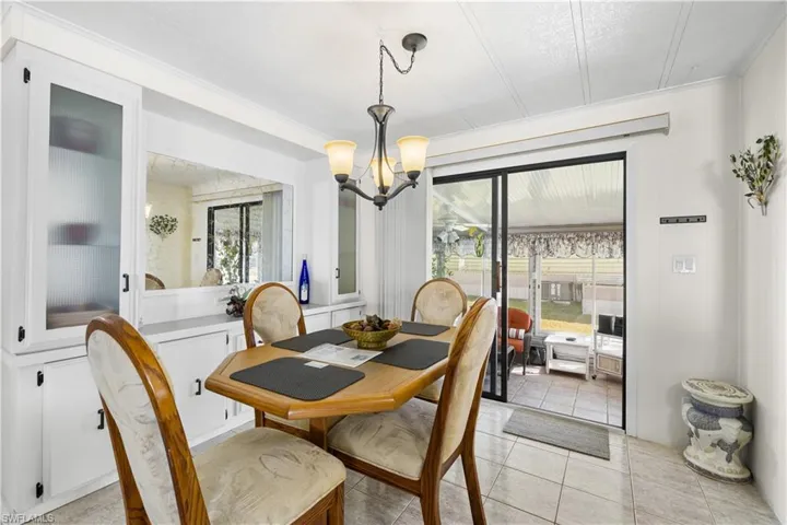 Dining room featuring crown molding, light tile patterned floors, and a chandelier