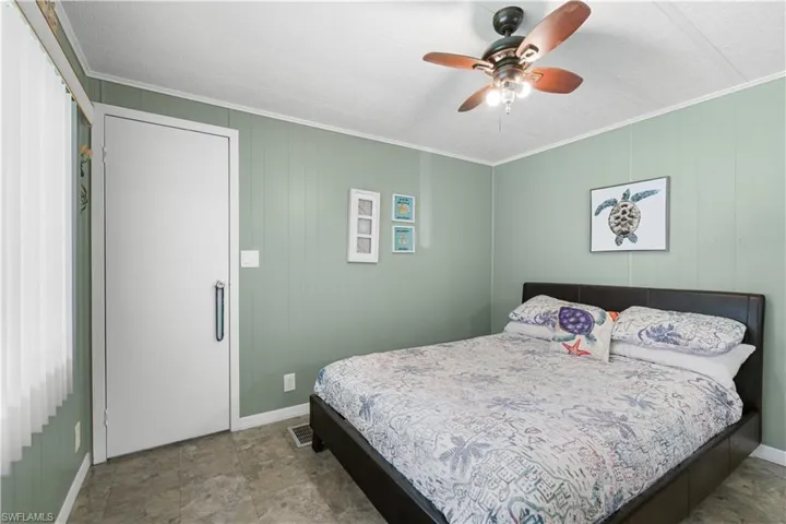 Bedroom with ceiling fan and ornamental molding