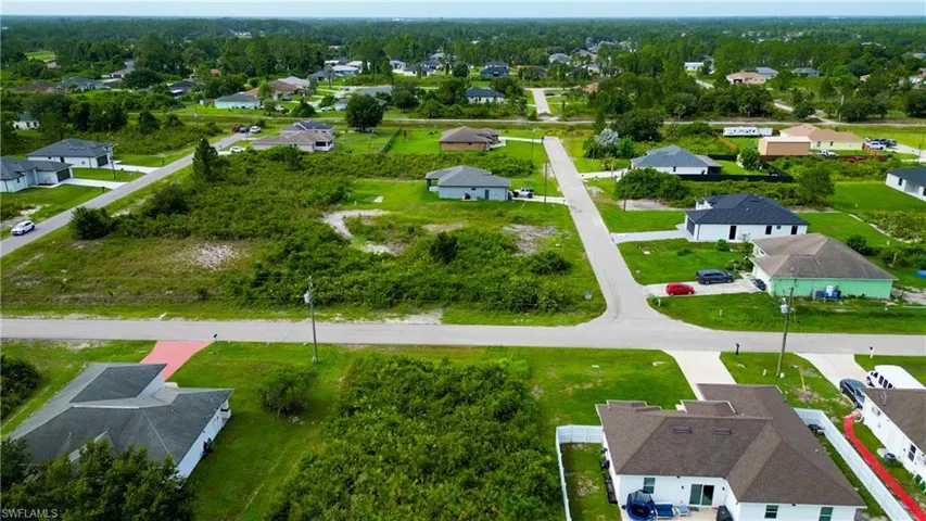 Spacious lot featuring undeveloped land surrounded by established residential properties and roadways