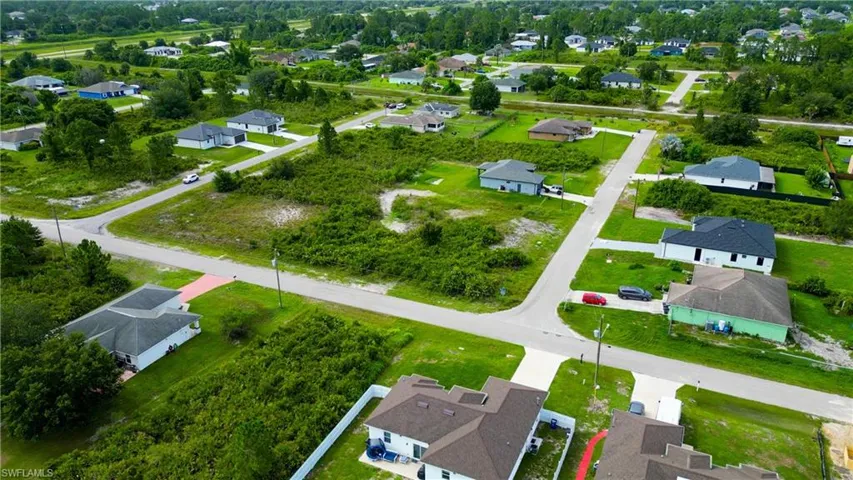 Aerial perspective showcasing multiple residential properties and undeveloped lots