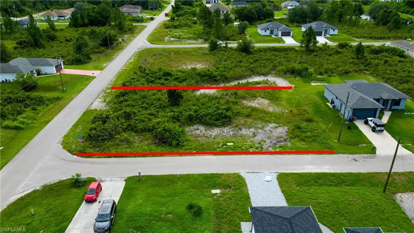 Corner lot property featuring a street-level location, surrounding green space, and partial clearing