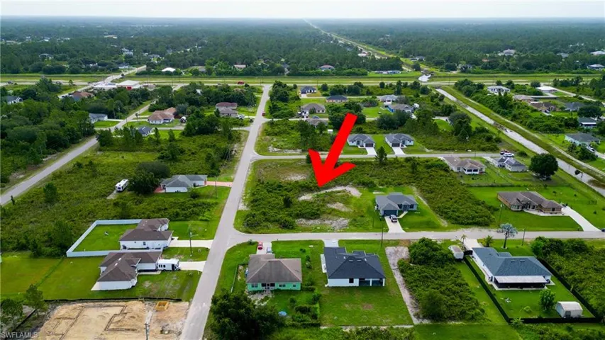 Vacant land parcel featuring a raw, undeveloped surface, surrounded by residential properties and paved roads