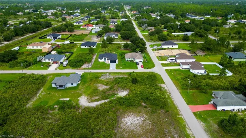 Aerial perspective showcasing a developing residential area with paved streets and established homes