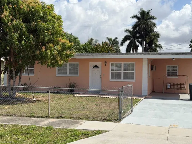 View of front facade with stucco siding, a gate, and concrete driveway
