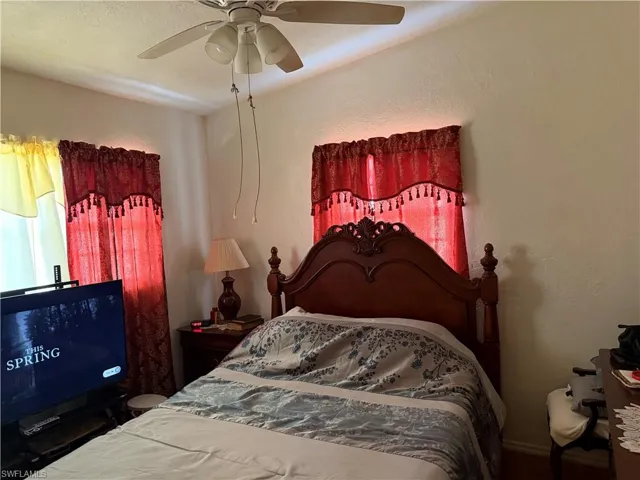 Bedroom with a textured wall and a ceiling fan