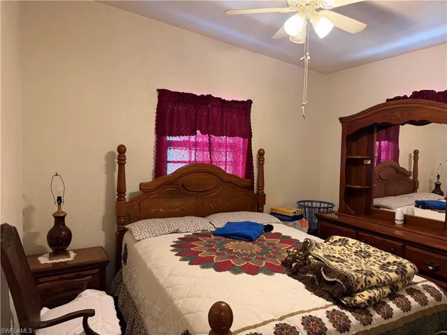Bedroom with ceiling fan and a textured wall