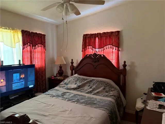 Bedroom featuring ceiling fan and a textured wall