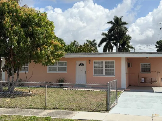 View of front of home featuring stucco siding, a gate, a carport, a fenced front yard, and driveway