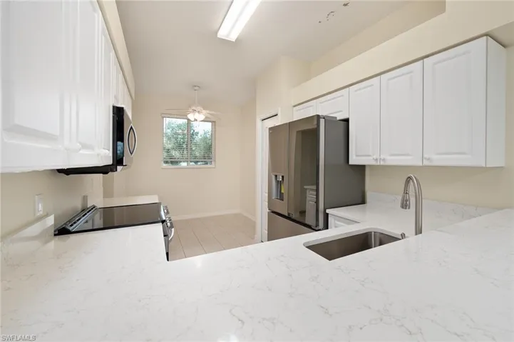 KITCHEN WITH BREAKFAST BAR - OPEN TO DINING & LIVING ROOMS. TIEL THROUGHOUT.
