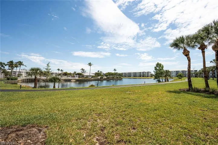 BACK OF CONDO WITH VIEW OF THE LAKE, POOL AND CLUBHOUSE AND WALKING TRAIL