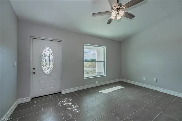 Entrance foyer with dark tile flooring and ceiling fan