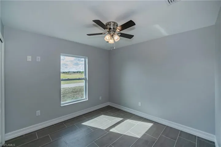 Tiled empty room with ceiling fan