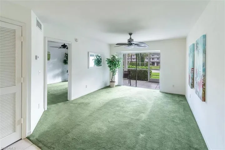 Empty room featuring light carpet and ceiling fan