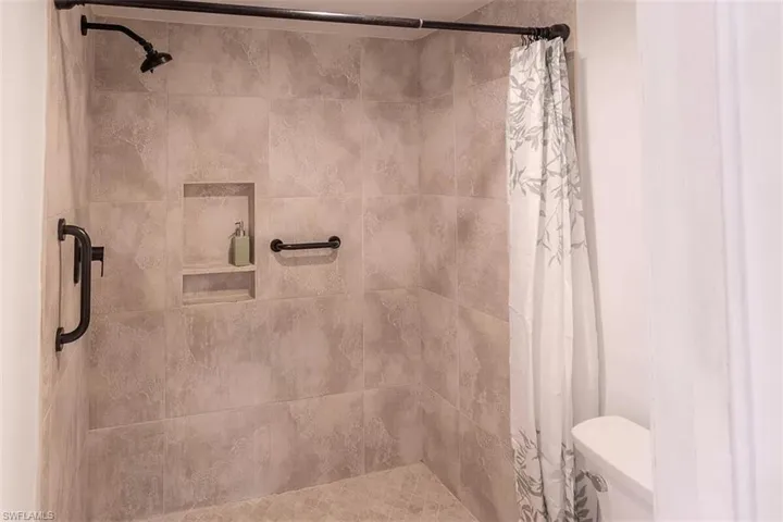 Bathroom with a shower with curtain and toilet