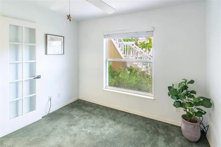 Carpeted empty room with ceiling fan