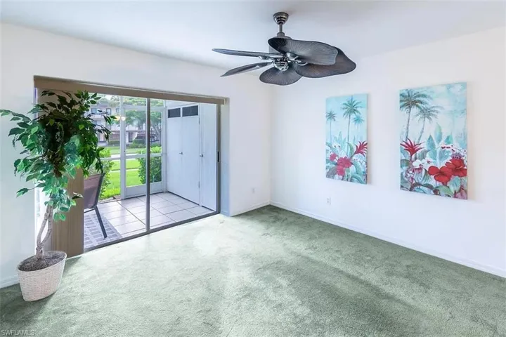 Carpeted empty room featuring ceiling fan