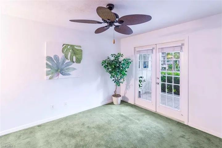 Carpeted empty room featuring french doors and ceiling fan