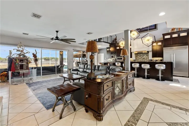 Living room with a ceiling fan and light tile patterned floors