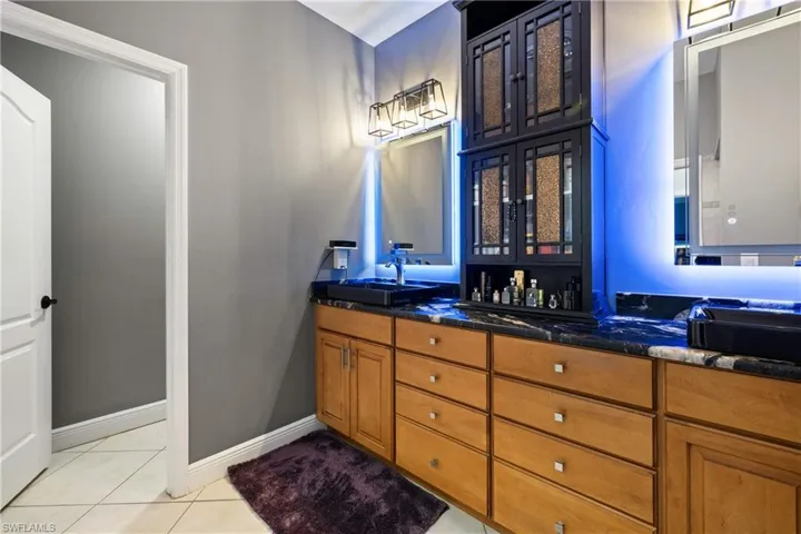 Bathroom with double vanity and light tile patterned flooring