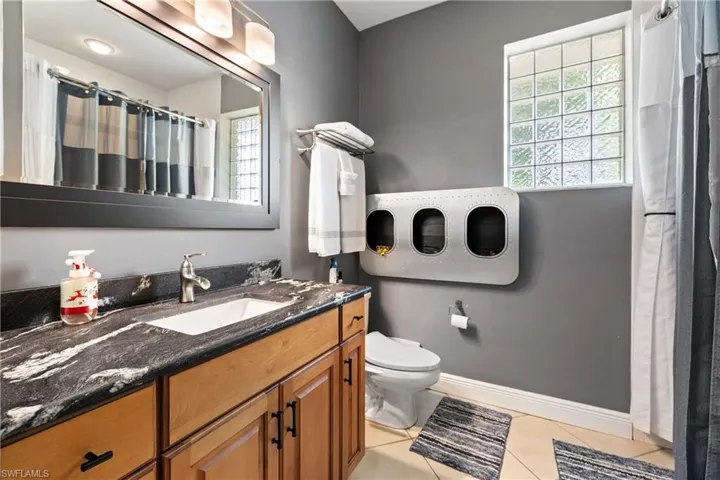 Bathroom with vanity, a shower with shower curtain, and light tile patterned floors