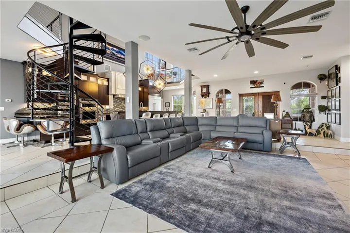 Living area featuring light tile patterned floors, a ceiling fan, and recessed lighting