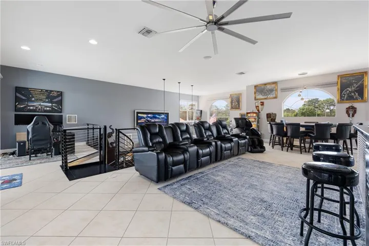 Home theater room featuring light tile patterned floors, ceiling fan, and recessed lighting
