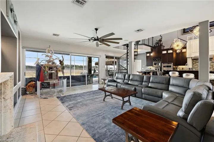 Living area featuring light tile patterned flooring and ceiling fan