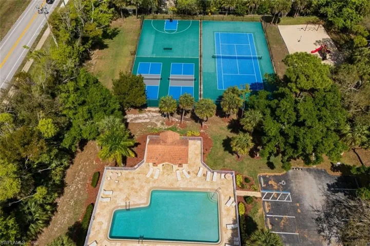 Drone / aerial view of a pool and a tree filled landscape