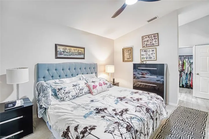 Bedroom featuring lofted ceiling, a spacious closet, and a ceiling fan