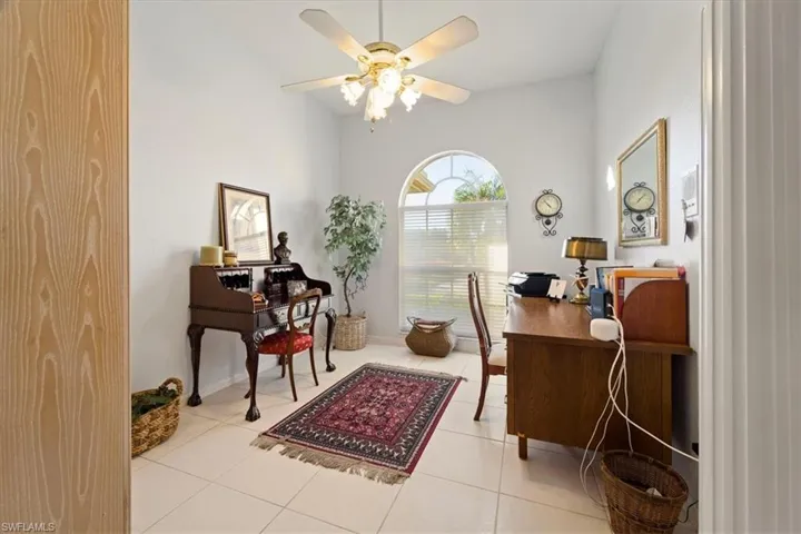 Office area with ceiling fan and light tile flooring